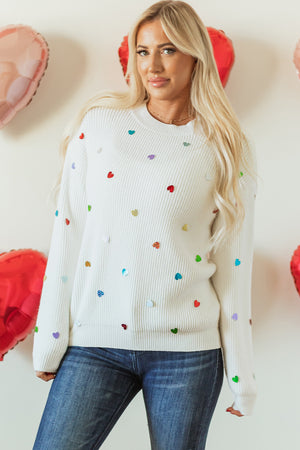 White ribbed knit sweater with colorful heart embellishments.