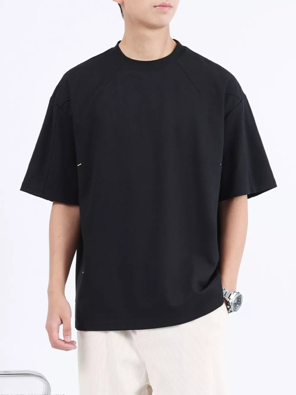 Black cotton crew neck oversized t-shirt with subtle white stitching details.