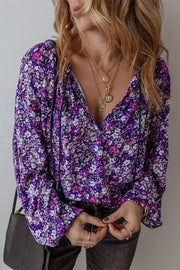 Floral print blouse in electric purple with blouson sleeves and tassel detail.