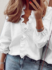 White blouse with cascading ruffle front and balloon sleeves.