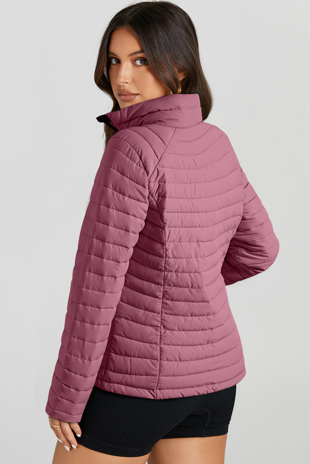 Quilted stand collar puffer jacket in a dusty rose color with horizontal quilting detail.