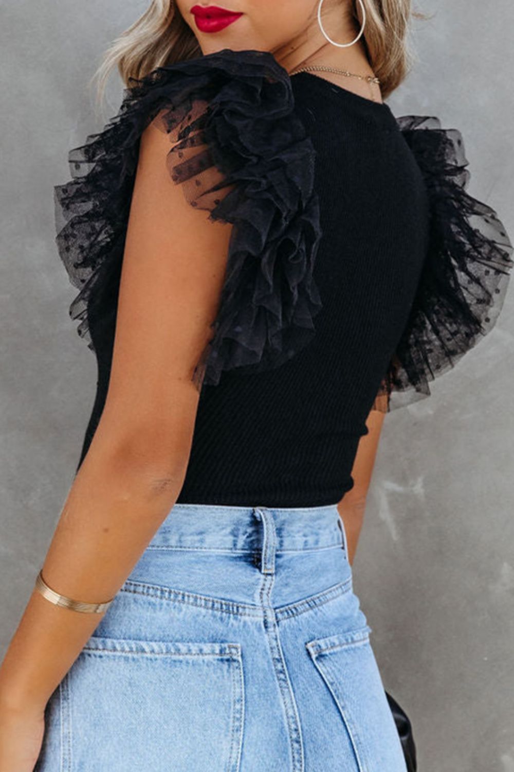 Black ribbed knit blouse with sheer polka dot tulle ruffle sleeves