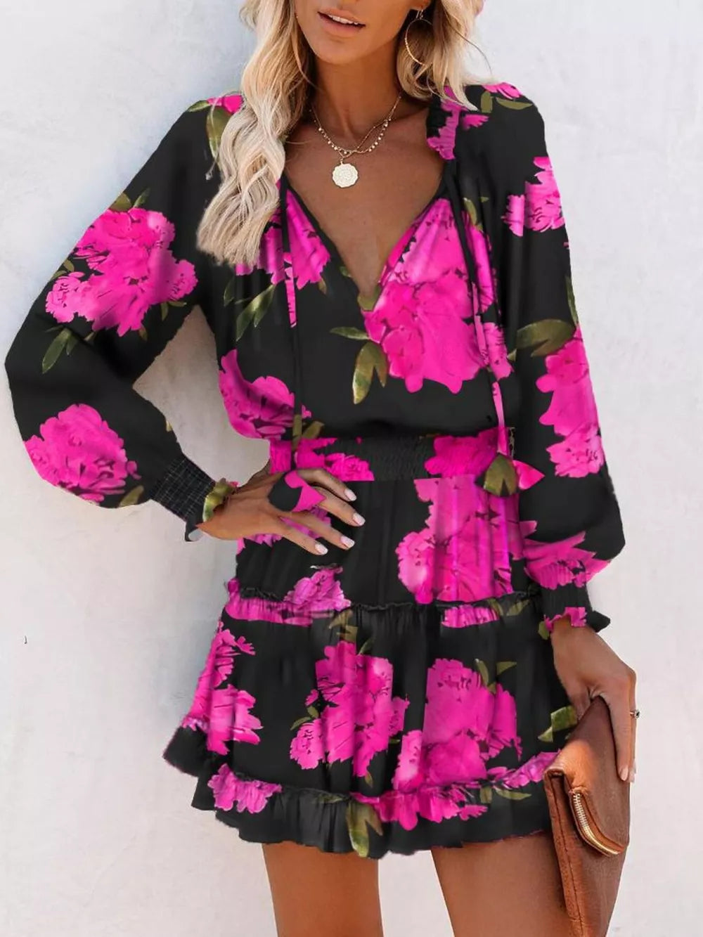 Black floral print tiered mini dress with ruffles and smocked cuffs.