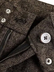Men's brown herringbone wide-leg trousers with zipper and button closure.