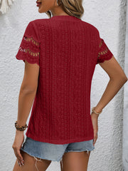 Burgundy eyelet blouse with scalloped short sleeves and intricate patterned fabric.