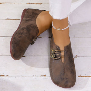 Dark brown round-toe casual flats with decorative buttons and elastic laces.