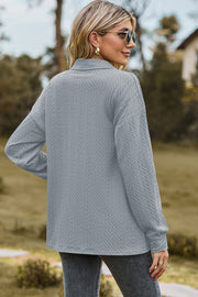 Textured polo-neck sweater in light blue with button detail and long sleeves.