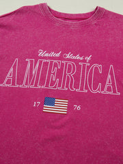 Patriotic graphic cotton t-shirt in pink with "United States of America" text and US flag graphic.