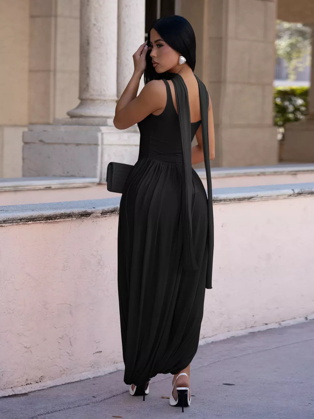 Black scoop neck maxi dress with draped fabric and a side slit, worn by a model.