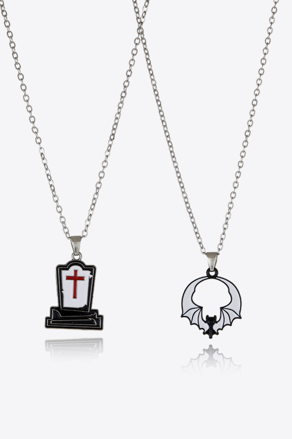 Spooky season necklaces with tombstone and bat enamel pendants on silver chains.