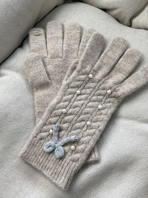 Khaki cable knit gloves with pearl embellishments and a bow detail.