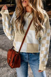 Colorblock checkerboard knit sweater in beige and white with crew neck and long sleeves.