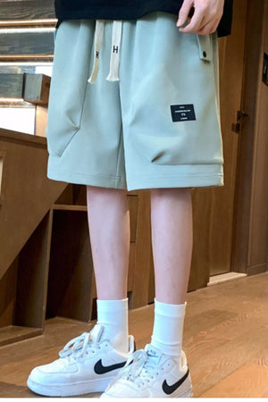 Men's sage relaxed fit chino shorts with drawstring and pocket detail.