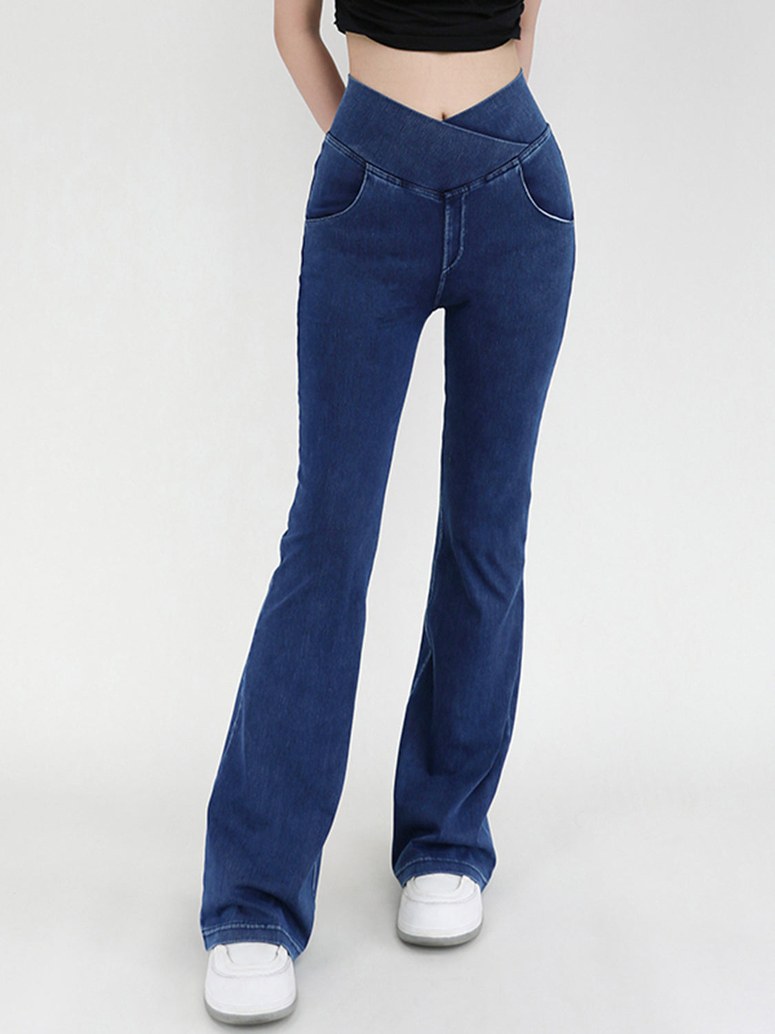 Medium wash denim flare jeans with a crossover waistband.