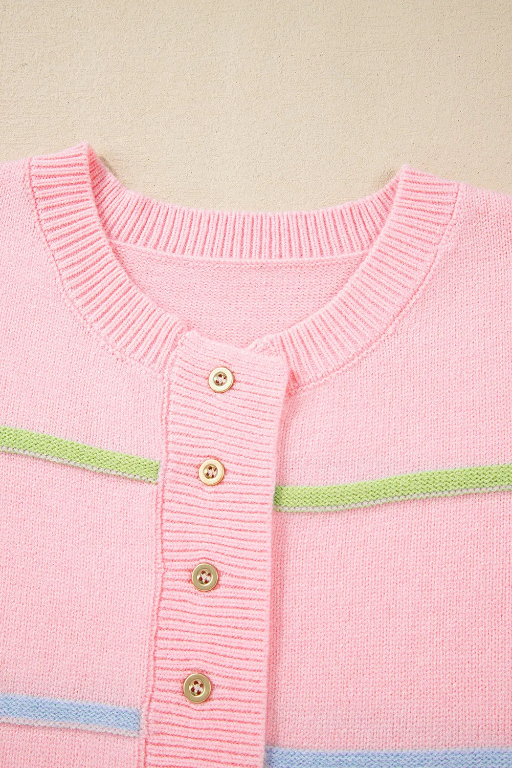 Blush pink knit henley sweater with pastel stripes and gold buttons.