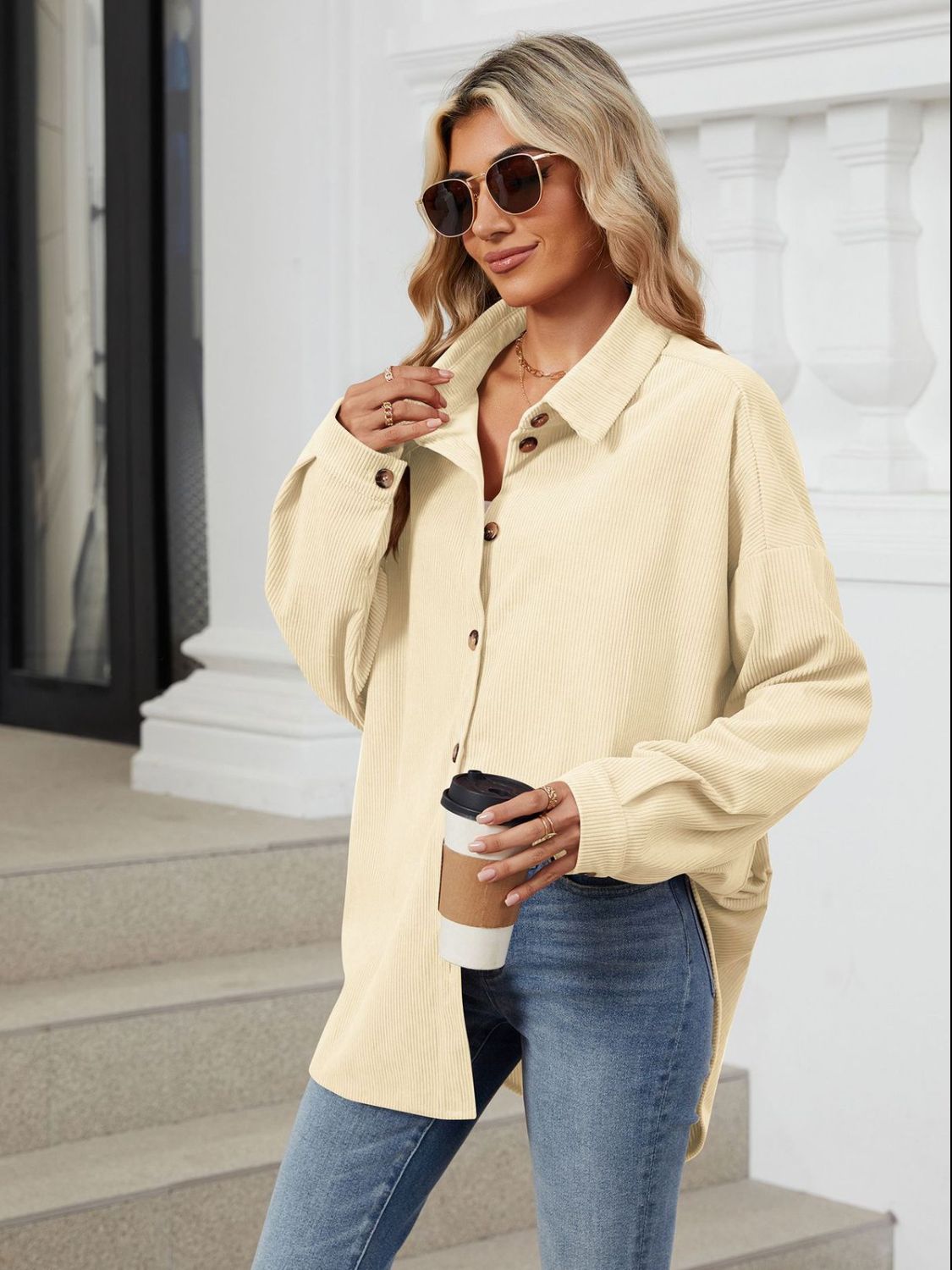 Oversized cream corduroy shirt jacket with button front and collar, styled casually.