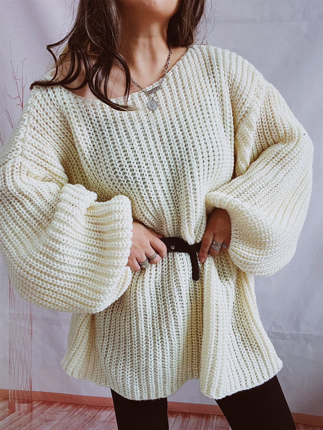 Cream oversized ribbed knit sweater with balloon sleeves and a belted waist.
