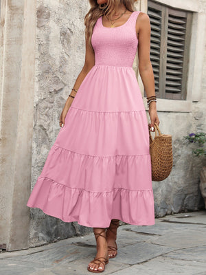 Pink smocked bodice tiered maxi dress with scoop neck and sleeveless design.
