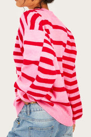 Colorblock stripe knit sweater in hot pink with balloon sleeves, styled with jeans.