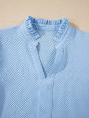 Light blue textured blouse with ruffled V-neck and collar