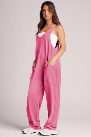 Relaxed fit hot pink jumpsuit with oversized pockets and a white tank top.
