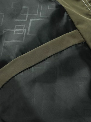 Green hooded jacket interior detail with geometric pattern lining and pocket trim.