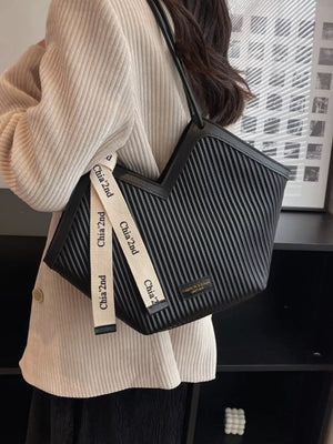 Black ribbed texture large shoulder bag with contrasting white straps.