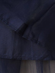 Navy tulle baby dress detail showing layered fabric and stitching.