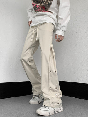 Men's beige sweatpants with snap button side detail and adjustable drawstring waist.