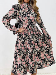 Black floral midi dress with pink roses, long sleeves, tie waist, and pleated skirt.
