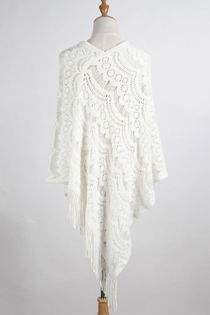 White crochet poncho with intricate pattern and fringe detail