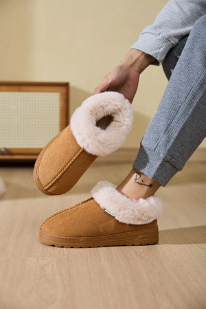 Caramel suede slippers with plush shearling trim, slip-on design.