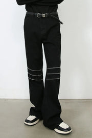 Black bootcut jeans with triple zipper detail at the knees.