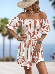 Off-the-shoulder mini dress with geometric print, shirred waist, and balloon sleeves in orange-red and white.