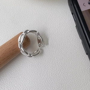 Sterling silver ring with interconnected oval links and a delicate chain detail.