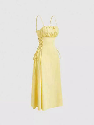 Light yellow cami dress with ruched bodice and crisscross lace-up sides.