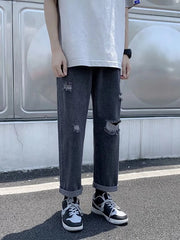 Distressed relaxed fit men's jeans in dark gray with cuffed hem and ripped details.