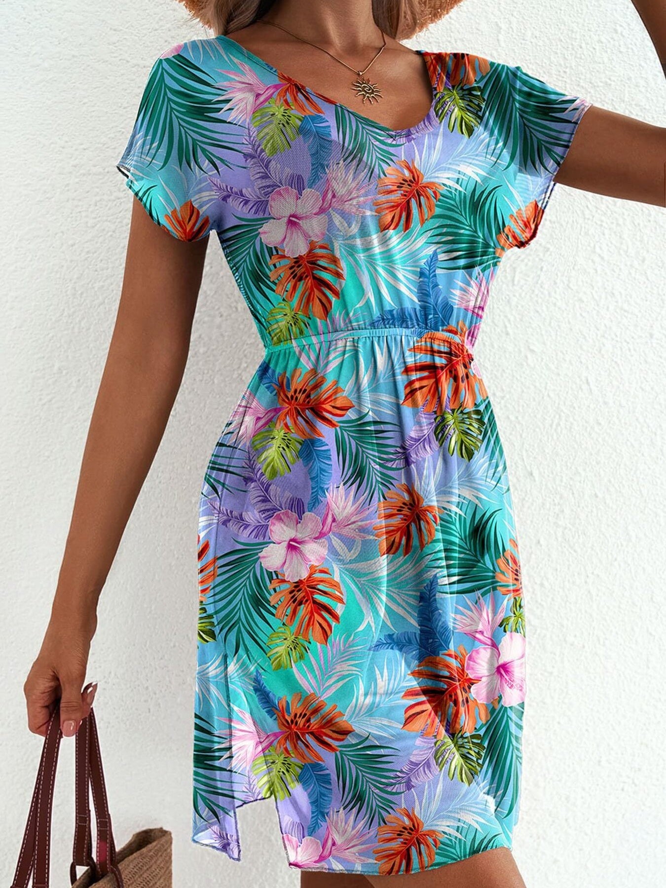 Vibrant leaf print mini dress in sky blue with short sleeves, v-neck, and a side slit.