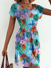 Vibrant leaf print mini dress in sky blue with short sleeves, v-neck, and a side slit.