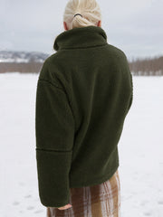 Olive green sherpa stand-collar jacket with textured fleece and seam detail on sleeves.