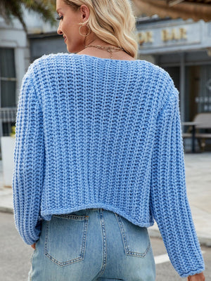 Sky blue chunky knit acrylic cardigan with a cropped hem and gold buttons.