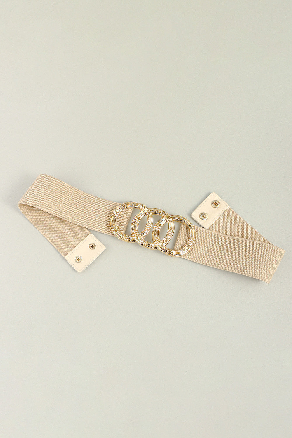 Tan elastic belt with triple gold interlocking ring buckle and snap closure.