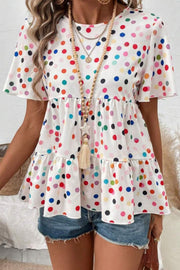 White polka dot tiered babydoll blouse with flutter sleeves and round neck.