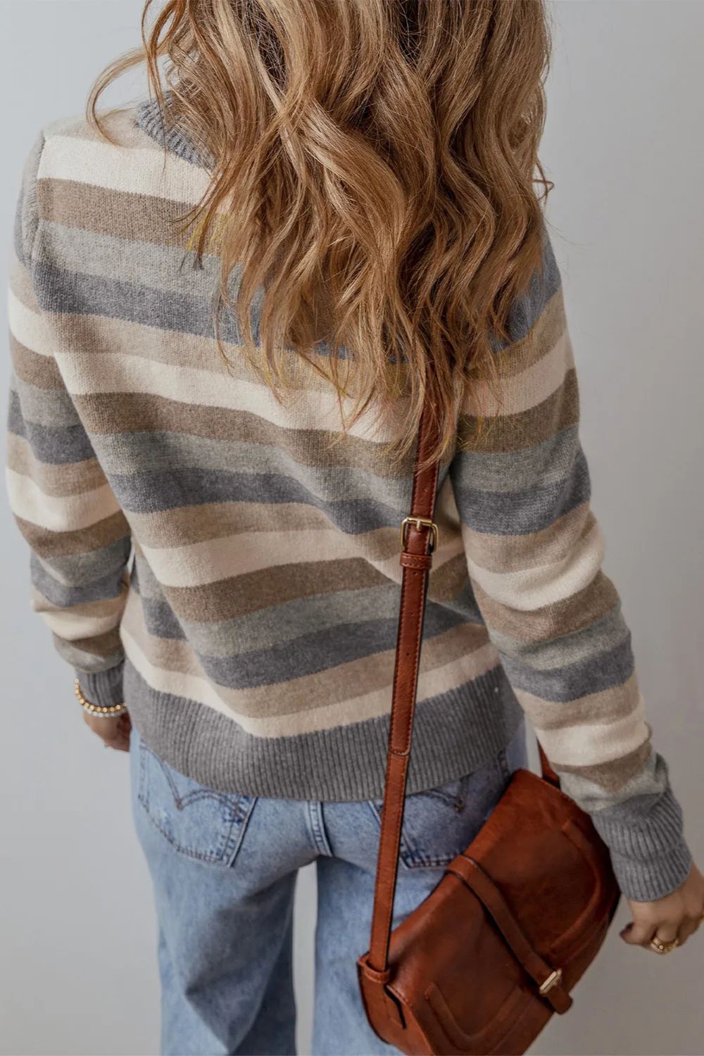Crewneck knit sweater with horizontal stripes in neutral tones, featuring a relaxed fit.