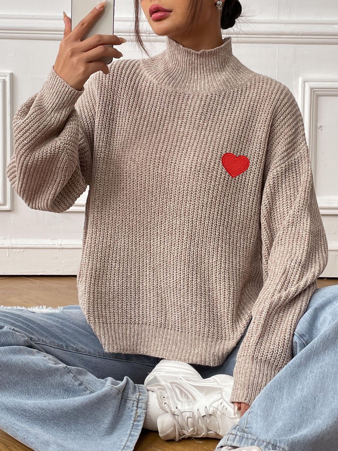 Khaki mock neck knit sweater with red heart appliqué, ribbed texture, and balloon sleeves.