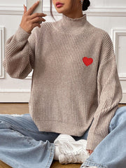 Khaki mock neck knit sweater with red heart appliqué, ribbed texture, and balloon sleeves.