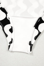 Black and white wave print one-piece swimsuit with a bow-front detail.