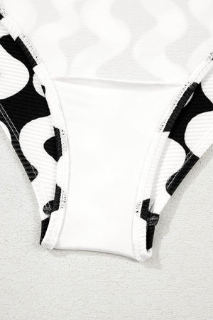 Black and white wave print one-piece swimsuit with a bow-front detail.