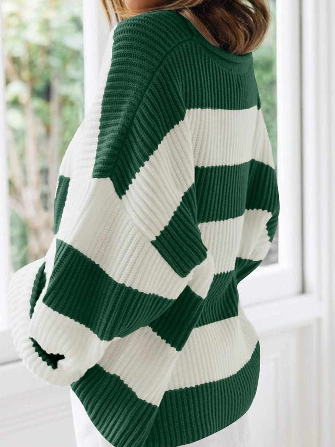 Striped oversized knit sweater in dark green and white with a crew neck.