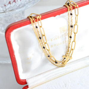 Gold layered chain and bead bracelet trio with cross charm detail